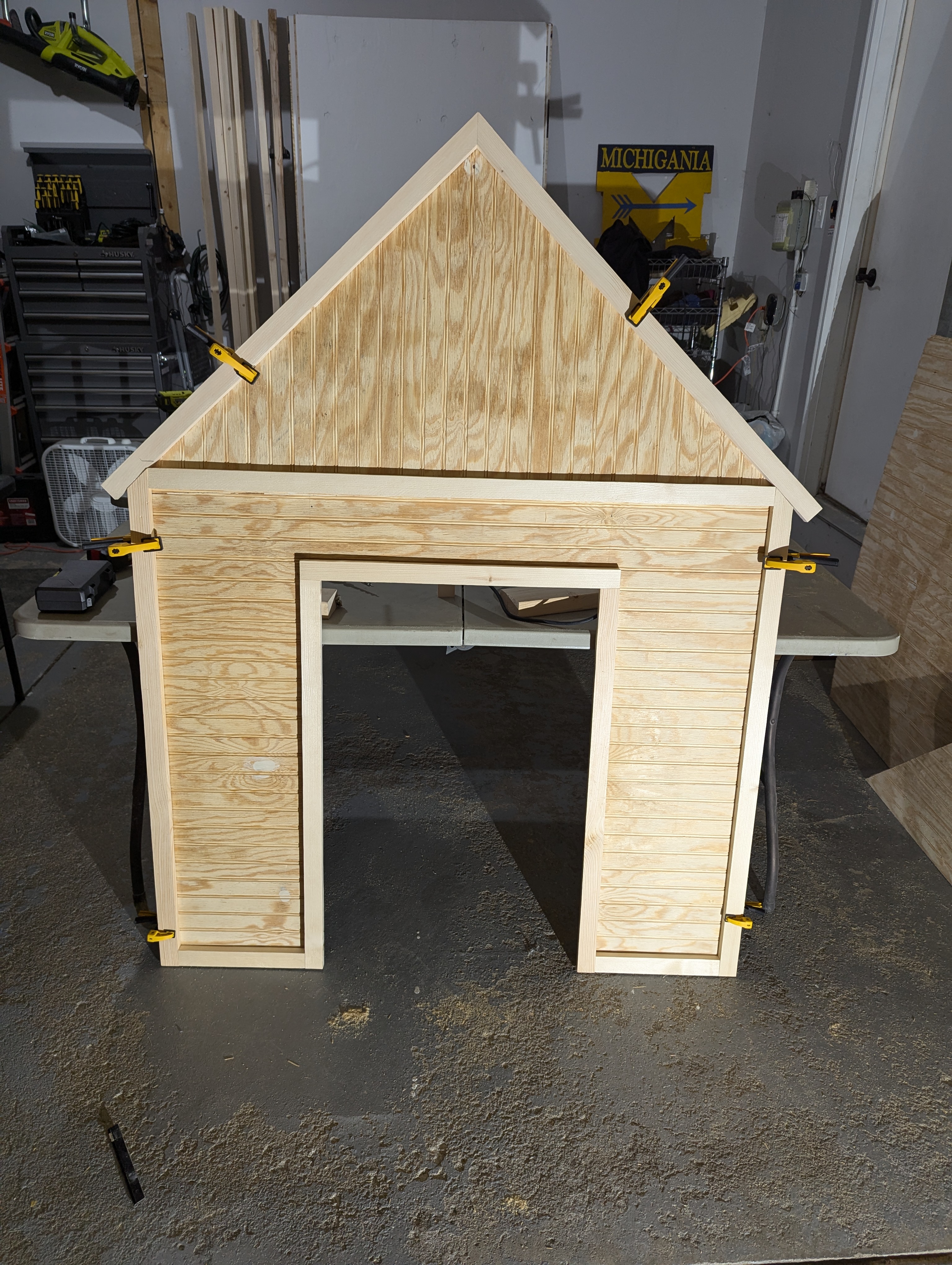 In-progress playhouse build with plans visible alongside partially built structure