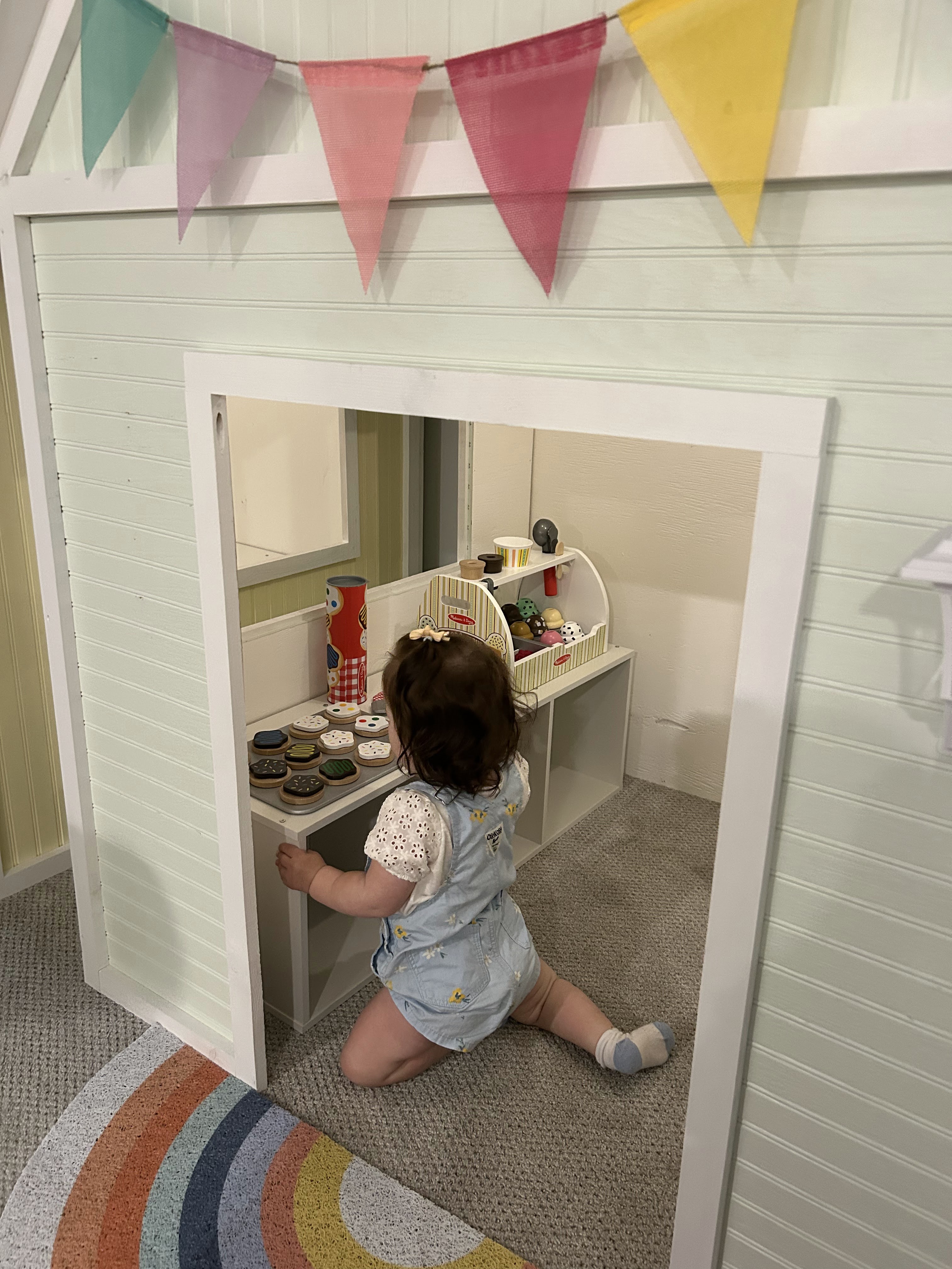 Child playing inside a custom wooden playhouse