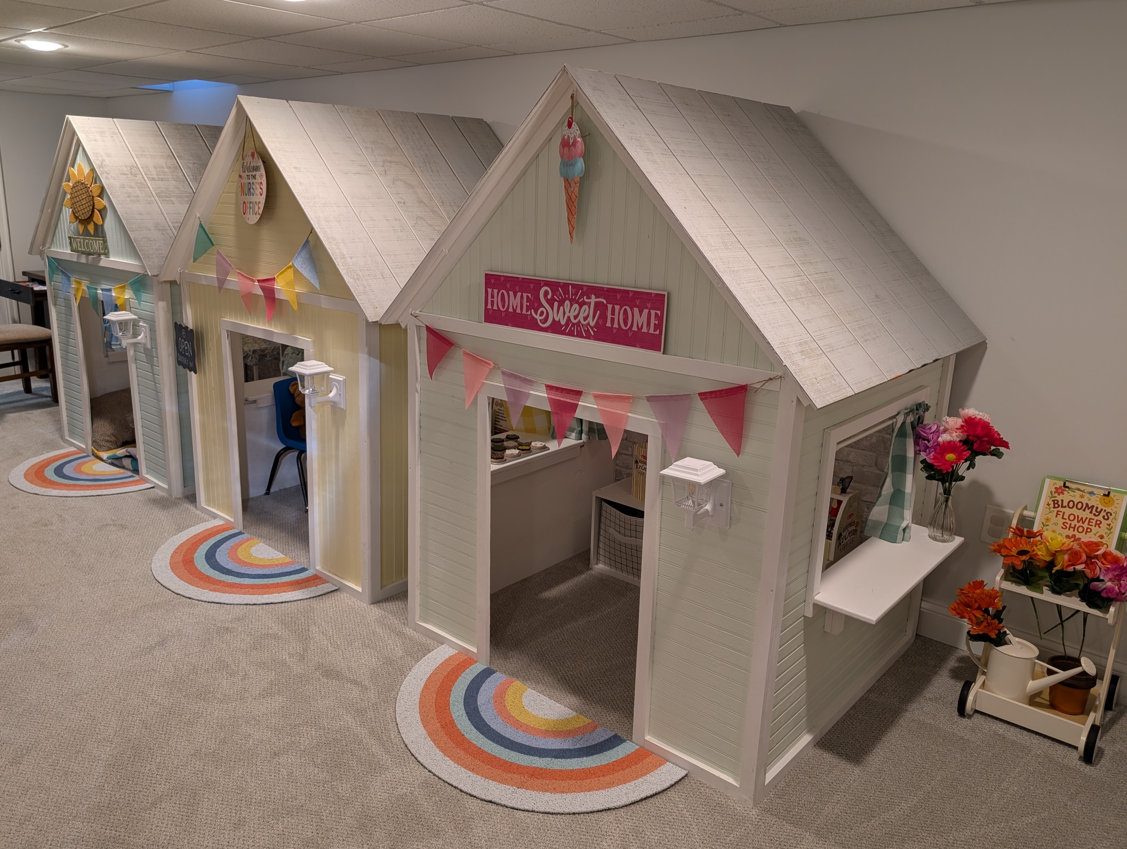 Three custom wooden playhouses arranged diagonally